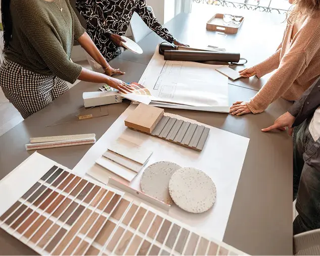 Planung einer Einbauküche mit Farbmustern, Holzmustern und Bauplan auf einem Tisch. Beratungssituation für moderne Küchenplanung mit Auswahl von Oberflächen, Arbeitsplatten und Fronten für eine individuelle Küche.